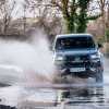 A Toyota Hilux GR pickup truck kicking up water on a trail.