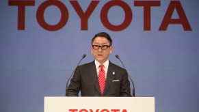 Akio Toyoda behind a Toyota podium during a press conference