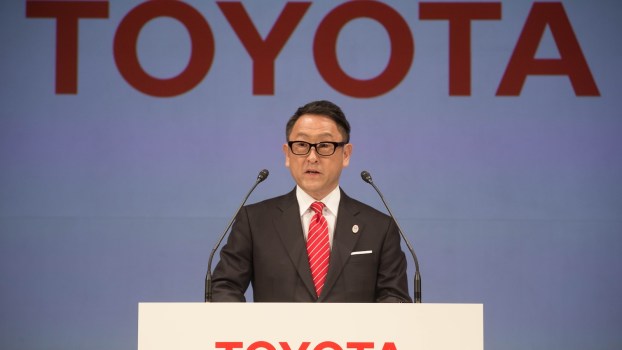 Akio Toyoda behind a Toyota podium during a press conference