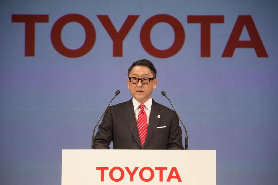 Akio Toyoda behind a Toyota podium during a press conference