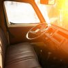 Classic pickup truck with a wide bench seat, the sun setting outside the windshield