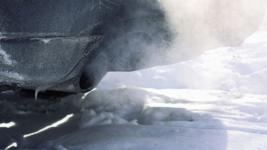 A cold car warming up in the cold weather, shown with exhaust plumes through the muffler