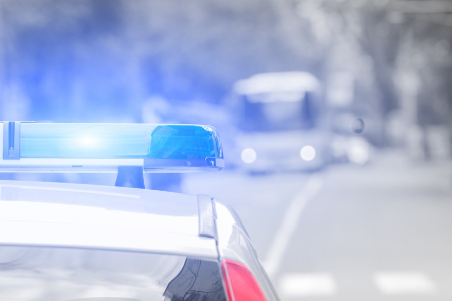 Cop car's roof with lights on in close rear view