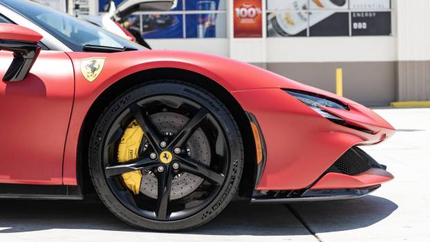 A red Ferrari SF90 in close right front profile view