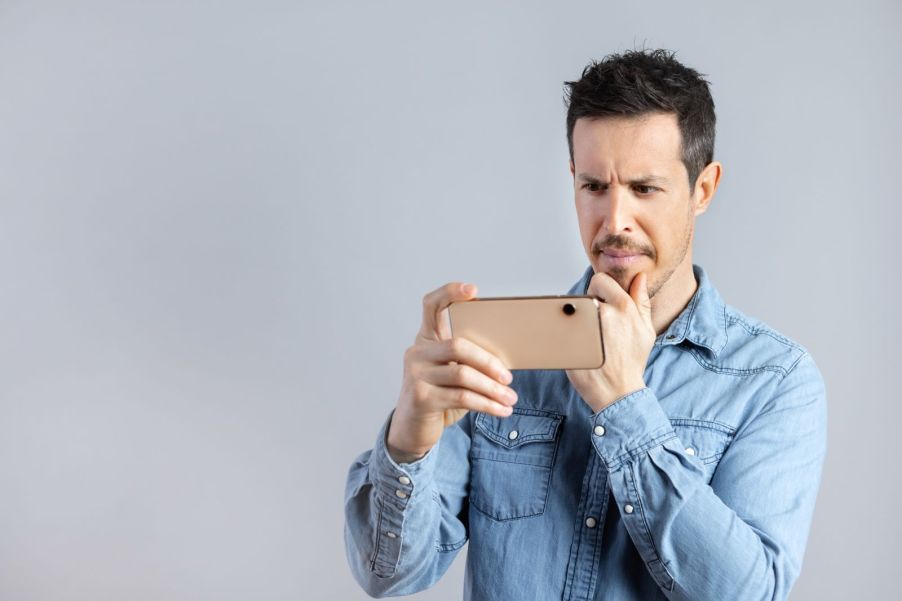 a man angrily filming with his phone