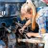 A young female mechanic working on a car