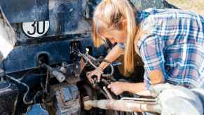 A young female mechanic working on a car