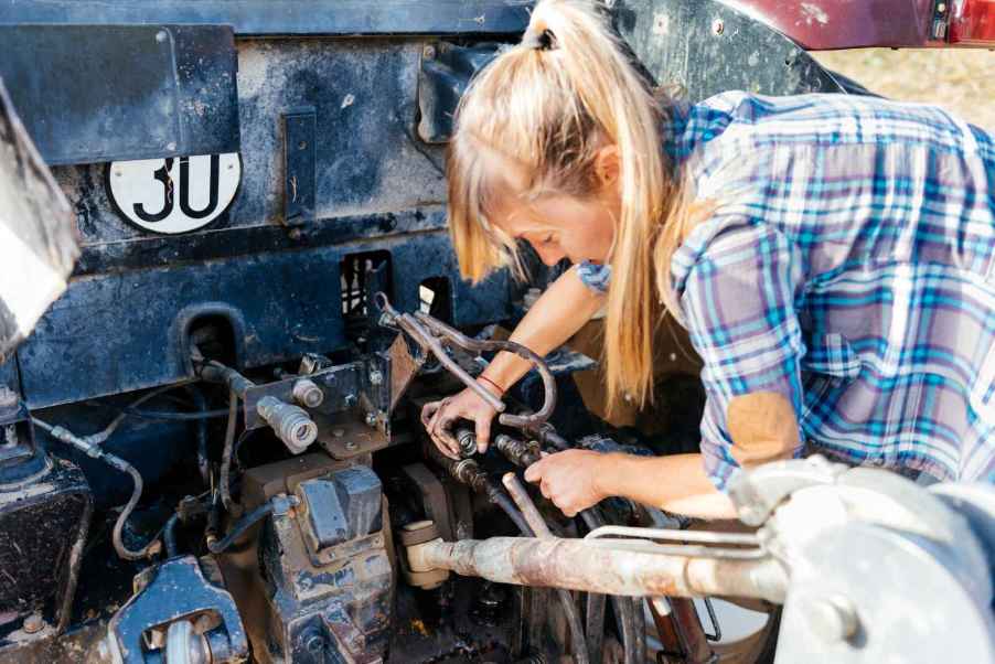 A young female mechanic working on a car