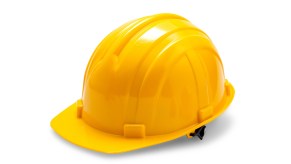 Yellow plastic construction hard hat on white surface