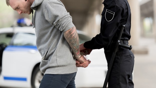 A man being arrested by a police officer