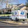 A USPS mail truck in a neighborhood