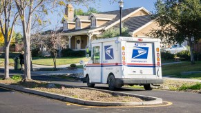 A USPS mail truck in a neighborhood