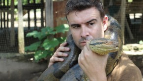 A man holding a large python