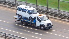 A van on the back of a tow truck