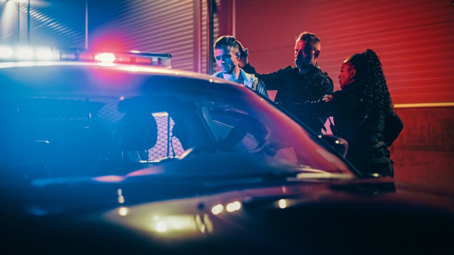 Two police officers arresting suspect at night