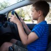 A little boy driving an SUV