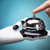 Robot hand holds a service bell while human hand presses bell top