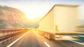 A blurred rear view of semi-truck driving on a highway