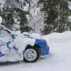 A blue 2002 Subaru Impreza being driven on a snowy road