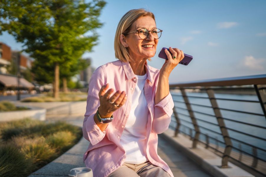 An elderly woman talking on speaker phone