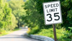 35 mph speed limit sign on a green brush-lined rural road